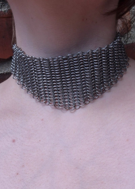 Zbliżenie na szyję z szerokim chokerem z kolczugi ze stali nierdzewnej, ręcznie robionym w stylu gotyckim, fantasy i średniowiecznym. Chainmaille biżuteria.