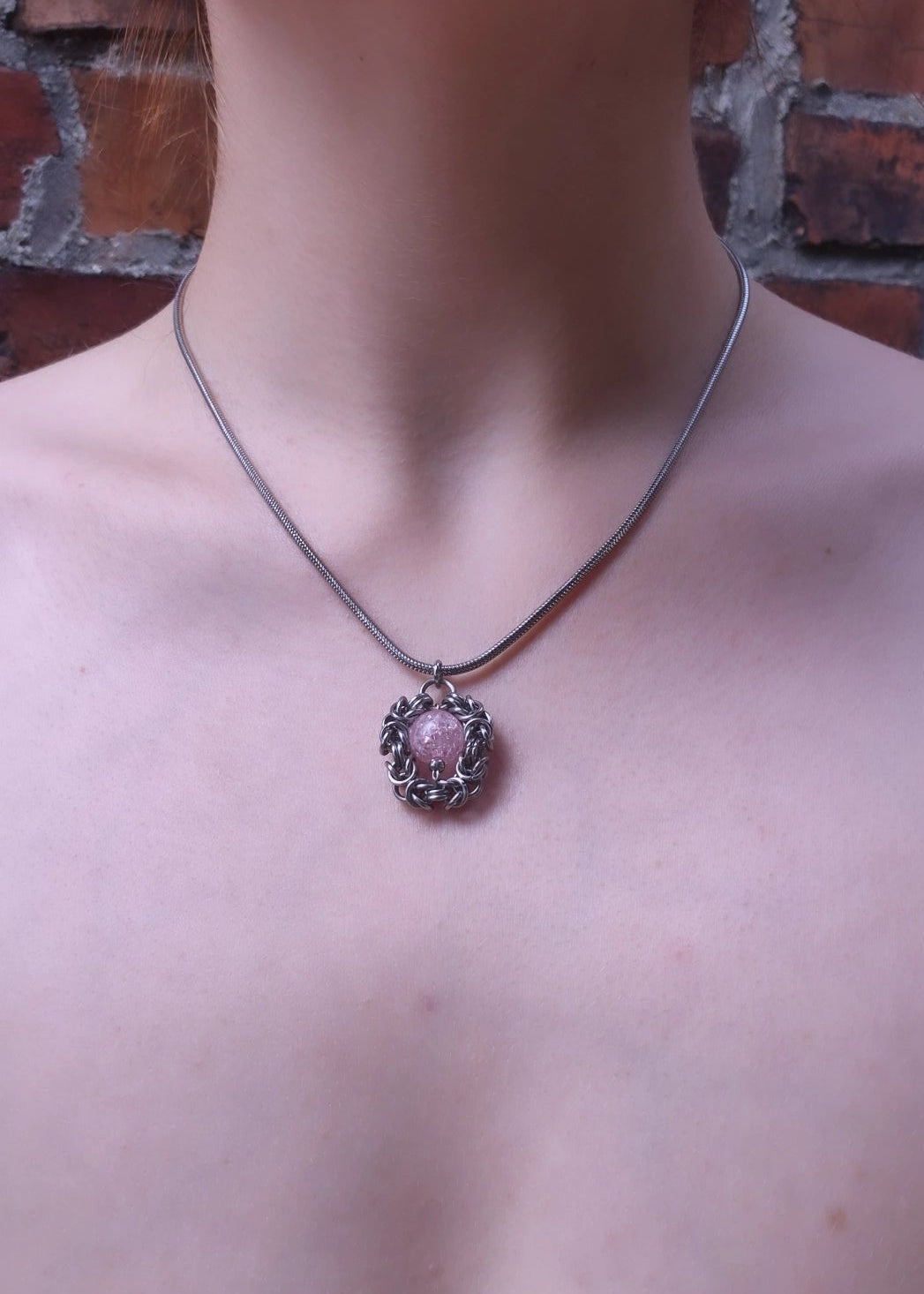 Handcrafted stinless steel chainmail  necklace with pink marble pendant worn on model outdoors