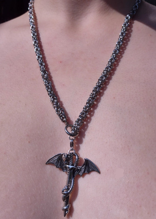 Gotycki naszyjnik z motywem smoka i miecza na masywnym łańcuszku chainmail, noszony jako klasyczny naszyjnik.